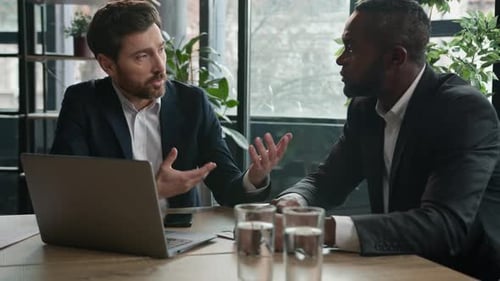 Two Diverse Multiracial Businessmen Discuss Laptop Corporate Project Problem in Office Solving