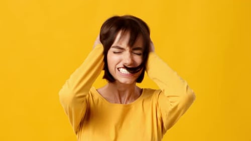Brunette Woman Expressing Emotion Against a Vibrant Yellow Background