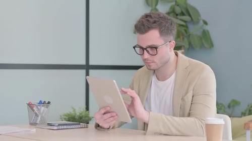 Cheerful Young Businessman using Tablet PC