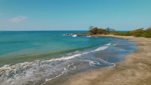 Aerial view tropical beach with gentle ocean waves on sunny day Costa Rica