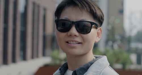 Smiling Young Adult in Sunglasses Close Up