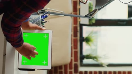 Person Holding Tablet with Green Screen Display