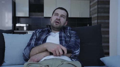 Man Reclining on Couch with TV Remote