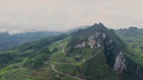Aerial view of winding road through mountains and rice terraces, Vietnam.