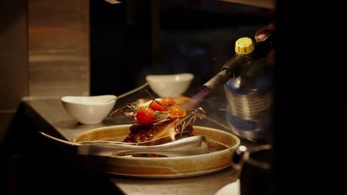A Chef Put Some Fire Over The Plate Of Food Using A Flame Gun. Close-up Shot
