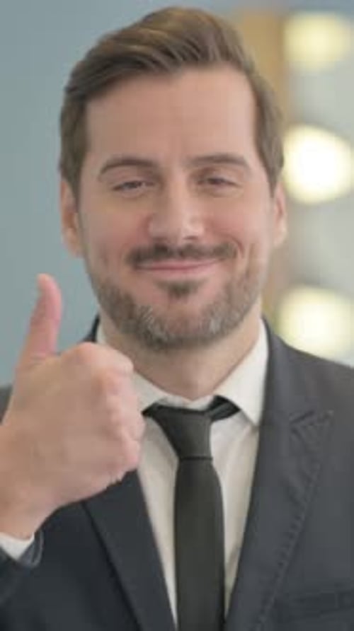 Smiling Man in Suit Gives a Thumbs Up