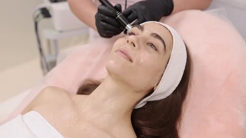 Woman Receiving Facial Treatment in Beauty Clinic