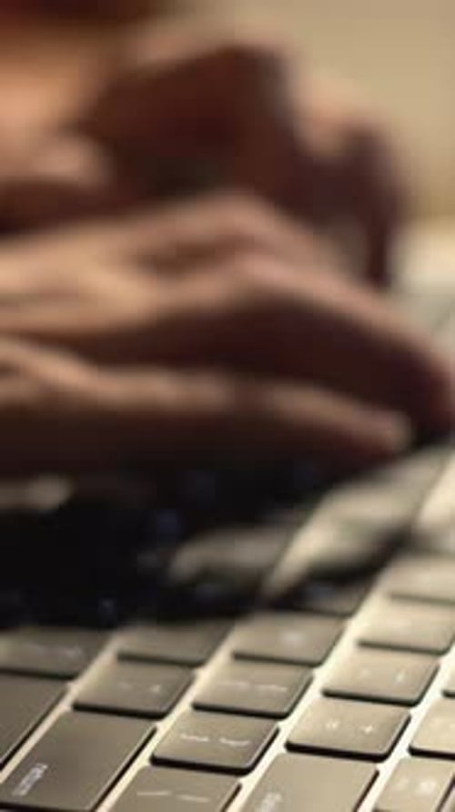 A Closeup View Showcasing Hands Actively Typing on a Contemporary Laptop Keyboard Set Against a