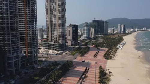 Aerial Drone Flight Over City Beach with View of Skycrapers and Tropical Beach