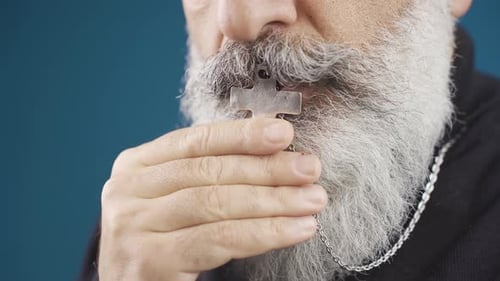 Man With White Beard Holds Metal Cross