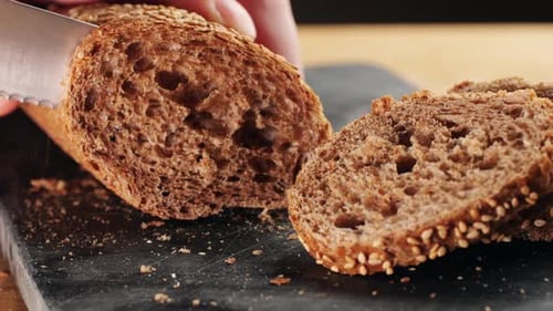 Close-up of Knife Cutting Fresh Bread Loaf
