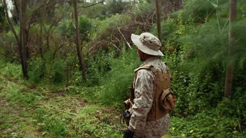Soldier In Uniform Under The Trees Of The Jungle