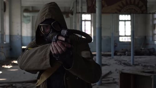 Ein Soldat in Militäruniform in einer Gasmaske mit einer Waffe in einem verlassenen Gebäude