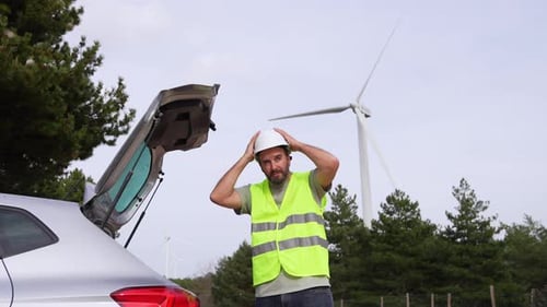 Technician Preparing for Work Next to Car in Wind Turbine Field