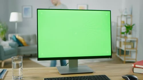 Modern Personal Computer with Green Mock-up Screen Display Standing on the Desk in the Cozy Living