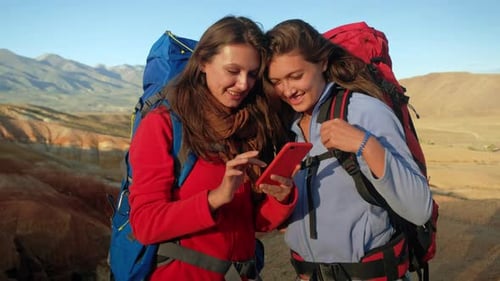 Female Friends Using Smartphone in Desert Landscape