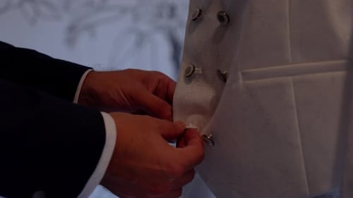 Man Fastening Buttons on White Wedding Vest