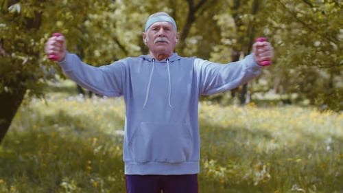 Senior Man Exercising Making Dumbbell Weight Lifting Exercises Practicing Sports Training in Park