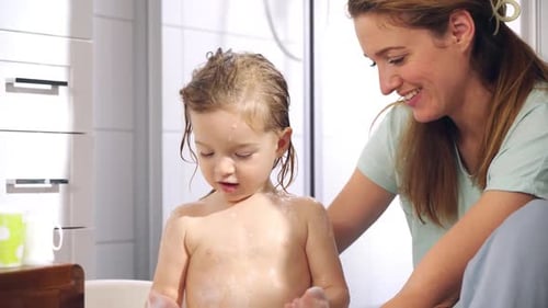 Happy Child Being Washed in Bathtub By Adult