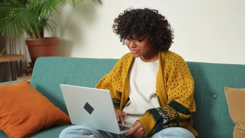 African American Girl Using Laptop at Home Office Looking at Screen Typing Chatting Reading Writing