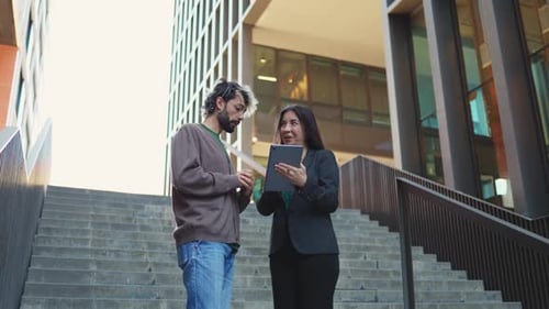 Businesswoman explaining contract details on a digital tablet to her business partner