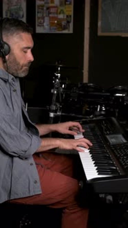 Musician Man Playing Keyboard Synthesizer Piano in a Recording Studio