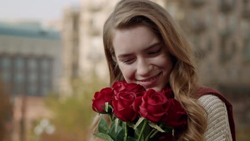 Smiling Woman Holding Roses Outside in the City
