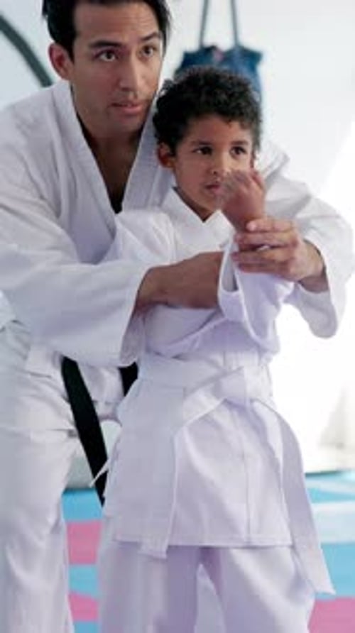 Man Teaching Child Karate Moves in Studio