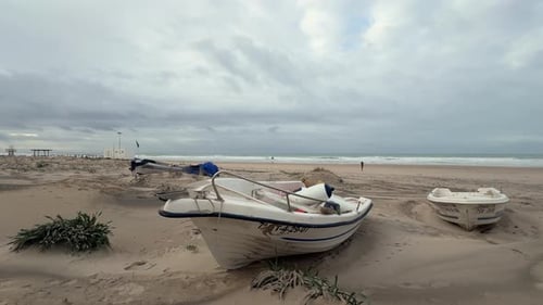 Time-lapse video showcasing the coastline and small boats on a sandy beach along the Spanish coast,