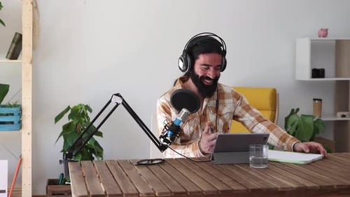 Man Recording Podcast Wearing Headphones at Table