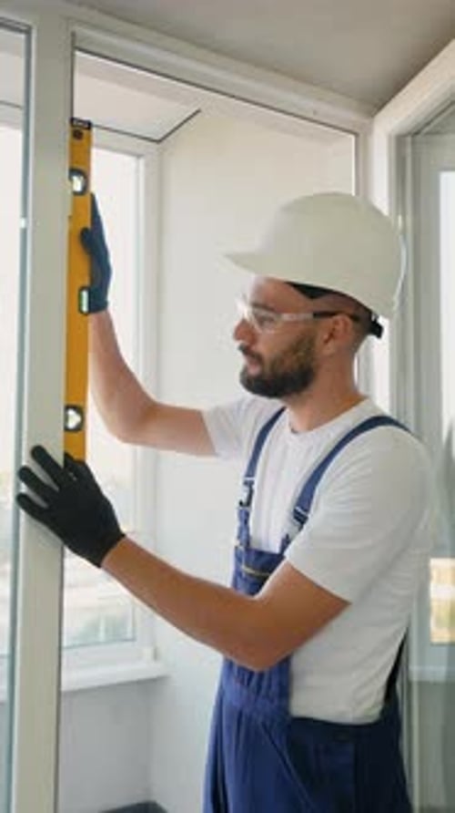 Worker Using Level to Ensure Precise Window Installation Alignment