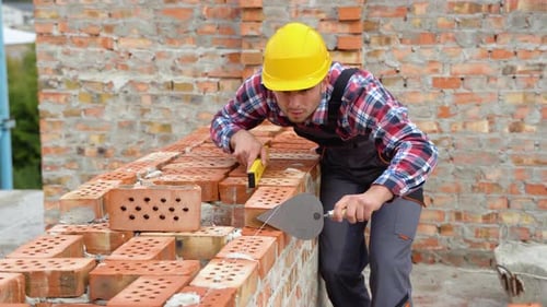 Man Laying Bricks at Construction Site