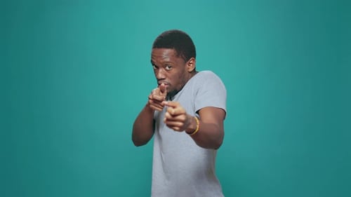 Man Pointing Index Fingers Like Guns on Teal