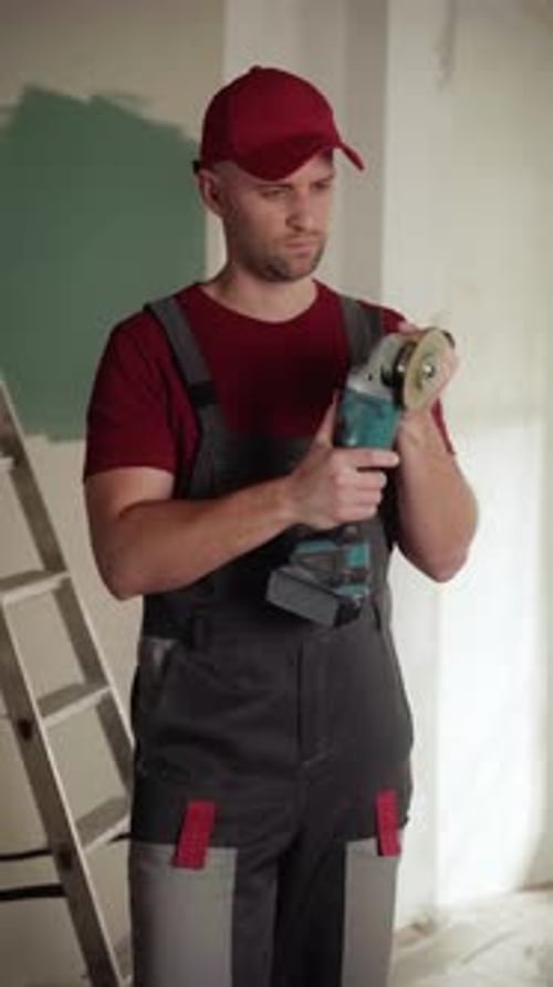 Construction Worker Checking Angle Grinder During Renovation Works