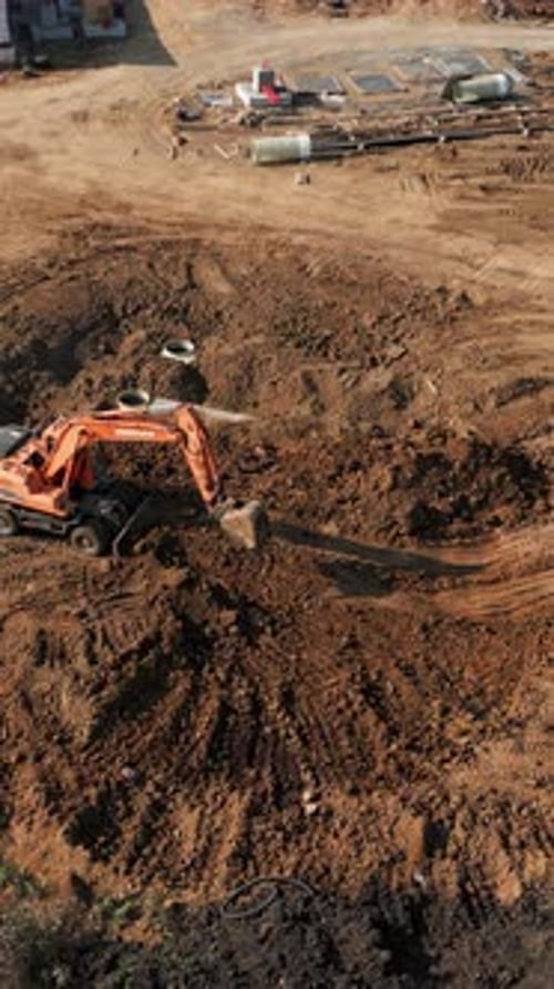 Excavator Digging and Moving Soil at Construction Site Clip