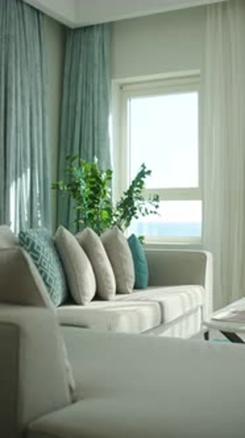 Une chambre lumineuse et confortable avec des meubles blancs de style loft, fenêtre d'un phare vertical