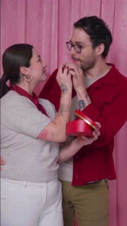 Latin Couple Sharing Chocolates From Heart Box in Valentine Photo Booth