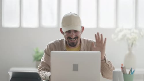 Bearded Man Uses Laptop for Video Call at Home