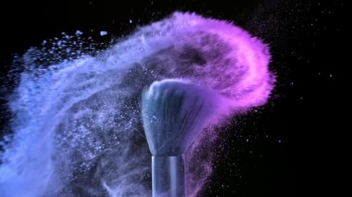 Pinceles de maquillaje con polvo de colores filmados en una cámara de alta velocidad a 1000 fps