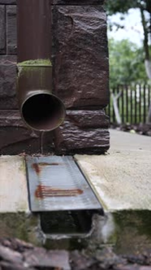 Water Draining from Rain Gutter into Drainage