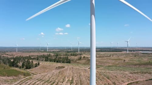 Towering Wind Turbines Generating Renewable Energy Across Expansive Rural Landscape White Spinning