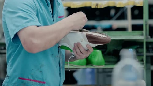 Man Gluing Shoe in Manufacturing Factory