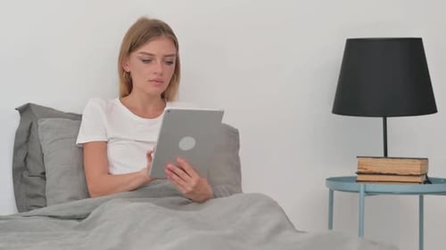 Woman Uses Tablet in Bed in the Daytime