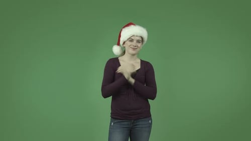 casual caucasian blond girl isolated on green with christmas hat