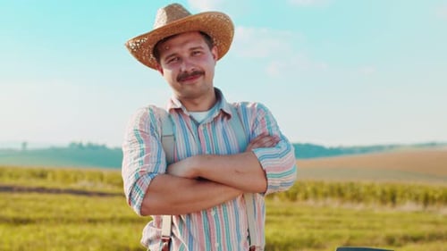 Portrait Shot of the Caucasian Man Farmer Standing in the Middle of the Wheat Field in the Sunlight