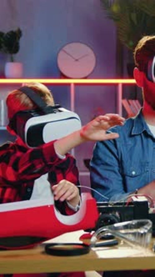 Child and Adult Wearing VR Headsets in Living Room