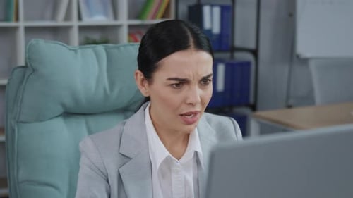 Portrait of Beautiful Frustrated Young Caucasian Woman Sitting at Computer and Looking at Monitor