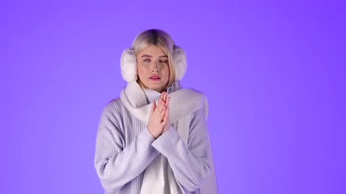 Blonde Woman Feeling Cold Rubbing Hands On Sweater Sleeves, Dressed In Winter Clothes, Studio Shot W