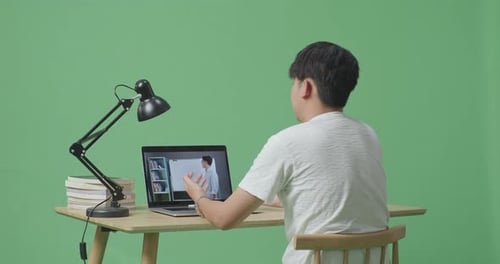 Asian Male Raising His Hand To Ask Question While Studying On Green Screen