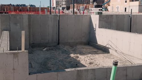 Schwenken Sie in Zeitlupe von rechts nach links über die Betonfundamentgrube auf der Baustelle